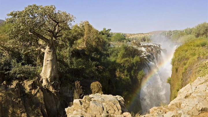 A waterfall creates a rainbow in Kunene River